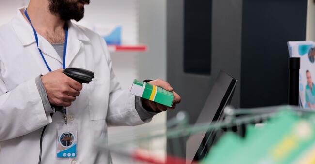 man-pharmacist-holding-store-scanner-that-reads-ba