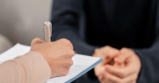 mid-shot-woman-therapist-taking-notes-clipboard (1