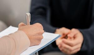 mid-shot-woman-therapist-taking-notes-clipboard (1
