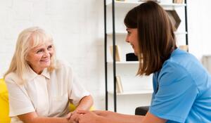medium-shot-old-woman-nurse-holding-hands